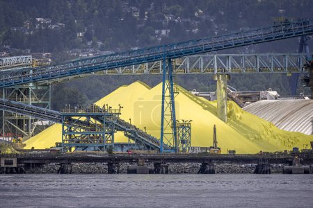 Foto de Grandes pilas de azufre amarillo en el paseo marítimo en North Vancouver, Columbia Británica, Canadá el 31 de mayo de 2023 - Imagen libre de derechos