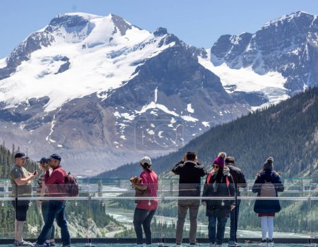Foto de Los turistas que admiran la vista desde la plataforma de observación con suelo de vidrio de la pasarela Columbia Icefield Skywalk en el Parque Nacional Jasper, Alberta, Canadá el 6 de junio de 2023 - Imagen libre de derechos