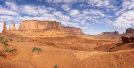 Panorama of Three Sisters formation and  large mesa from the valley floor in Monument Valley, Arizona, USA on 21 April 2024