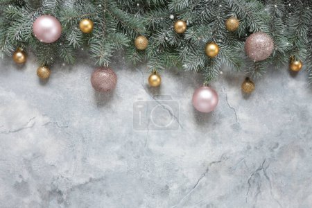 Téléchargez les photos : Composition festive de Noël et du Nouvel An avec branches de sapin des neiges, douces boules de Noël roses et dorées sur fond de marbre - en image libre de droit