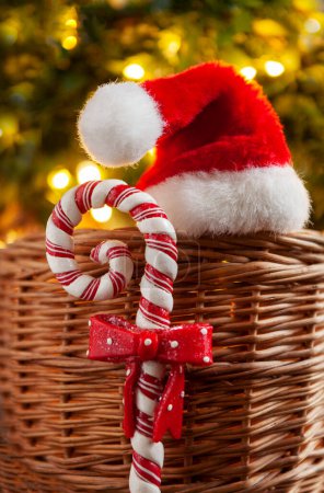 Téléchargez les photos : Composition de Noël avec le chapeau du Père Noël et son personnel sur le fond d'un arbre de Noël dans les lumières - en image libre de droit