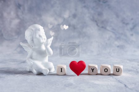 Téléchargez les photos : Figurine en porcelaine blanche d'un ange et les mots que je t'aime avec un cœur rouge - en image libre de droit