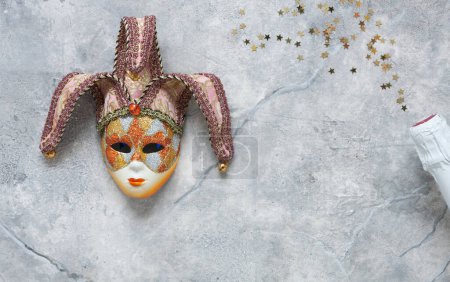 Photo for Carnival mask, white champagne bottle and gold glitter confetti. Top view, Close up on marble background. - Royalty Free Image