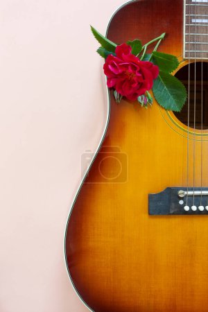 Photo for Close up of Acoustic guitar with beautiful blossoming viva magenta rose flower - Royalty Free Image