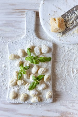 Téléchargez les photos : Traditional homemade raw italian potato gnocchi on white wooden background - en image libre de droit