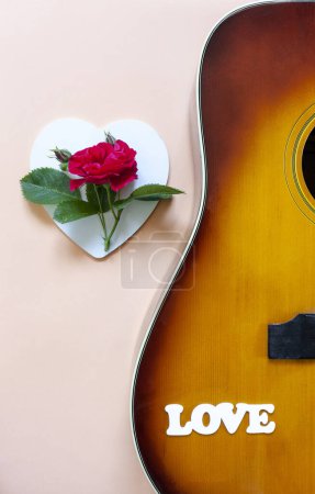 Téléchargez les photos : Close up of Acoustic guitar with beautiful blossoming rose flower and word Love - en image libre de droit