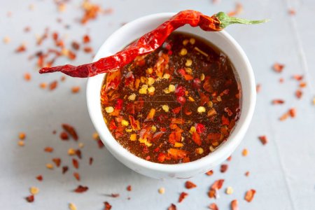 Photo for Spicy or hot chilli honey in the bowl with dry chilli pepper - Royalty Free Image