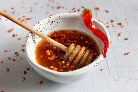 Spicy or hot chilli honey in the bowl with dry chilli pepper