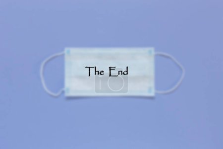 Photo for The inscription The End on a blurred background of a medical mask. End of the Covid19 Coronavirus Pandemic - Royalty Free Image