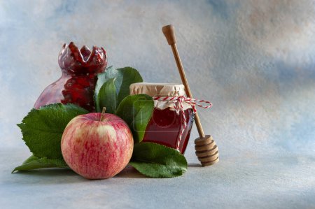 Photo for Apple, pomegranate, honey. Concept for Rosh Hashanah the Jewish New Year. Close up on light blue background. - Royalty Free Image