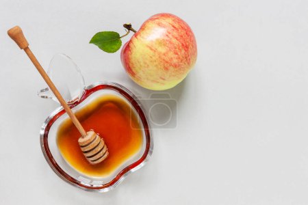 Téléchargez les photos : Pomme et miel. Concept pour Rosh Hashanah le Nouvel An juif. Gros plan sur fond bleu clair. Vue de dessus, gros plan, plan plat - en image libre de droit