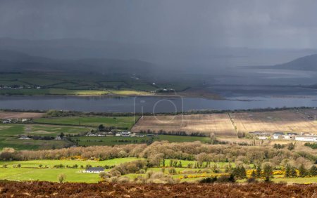 Foto de Vista panorámica del paisaje de Lough Foyle y Lough Swilly en el comienzo de fuertes lluvias desde la cima de Grianan of Aileach - An Ancient Stone Ringfort in Co. Donegal, Irlanda - Imagen libre de derechos