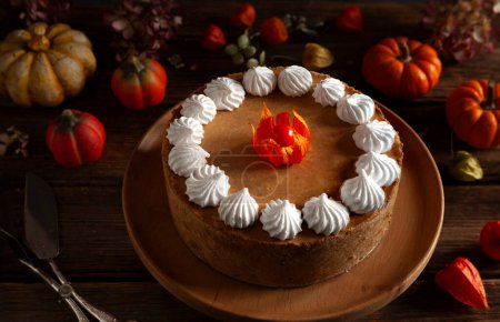 Photo for Pumpkin cheesecake with meringue on the cozy autumn background. - Royalty Free Image
