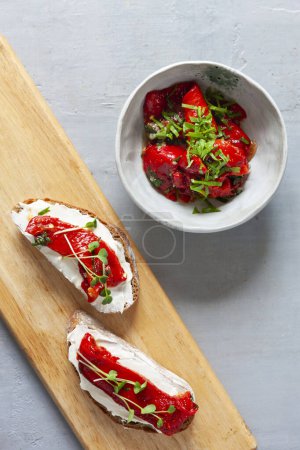 Photo for Appetizer from Grilled roasted and peeled red peppers on ciabatta slices with soft cream chees - Royalty Free Image