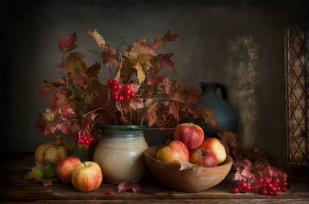 Téléchargez les photos : Nature morte aux pommes et viorne écarlate branches d'automne et baies dans un style vintage. - en image libre de droit
