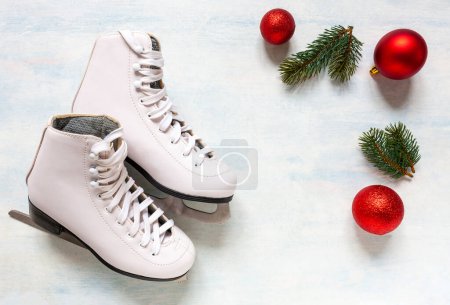 Photo for White figure skates and Christmas decorations on the blue light background - Royalty Free Image