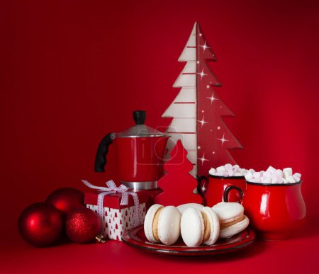 Photo for Festive Christmas New Year composition in red with balls, two hot drink mugs with marshmallow, french macaroon cookies on red background - Royalty Free Image