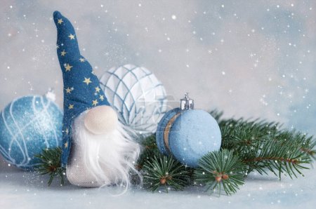 Foto de Gnomo de Navidad Gonk con un sombrero azul con barba larga con decoraciones y galleta macaron. Año nuevo y diseño de tarjetas de felicitación de Navidad. - Imagen libre de derechos