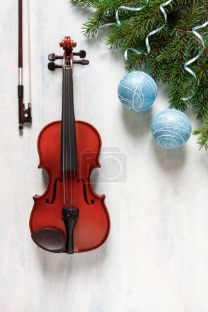 Foto de Old violin and fir-tree branches with Christmas decor and white poinsettia. Christmas, New Year's concept. Top view, close-up. - Imagen libre de derechos