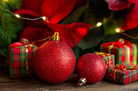 Photo for Festive composition with Christmas red fir tree balls and traditional gift boxes. Christmas and New Year home holidays concept. - Royalty Free Image