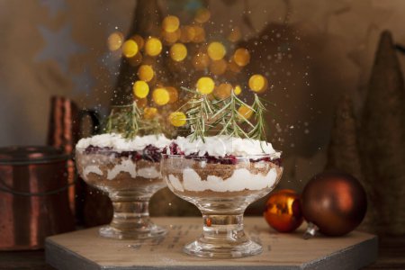 Photo for Latvian, scandinavian traditional rye bread layered dessert with whipped cream and cowberry jam served in glass on the Christmas New Year festive table setting - Royalty Free Image