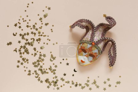 Photo for Festive background with carnival mask and golden glitter confetti in Peach Fuzz Color background of the year 2024 - Royalty Free Image