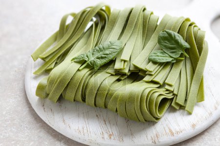Téléchargez les photos : Pâtes italiennes tagliatelles maison aux épinards verts non cuites gros plan - en image libre de droit