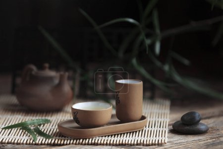 Téléchargez les photos : Ensemble traditionnel de cérémonie du thé vert théière blanche et tasses avec des pierres piramide, maison pour l'âme, sur le tra - en image libre de droit