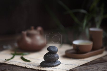 Foto de Conjunto tradicional de ceremonia del té verde - tetera blanca y tazas con piedras piramida, casa para el alma, en el tra - Imagen libre de derechos