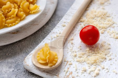 Photo for Uncooked Creste di Gallo pasta and ingredients for it cooking - Royalty Free Image