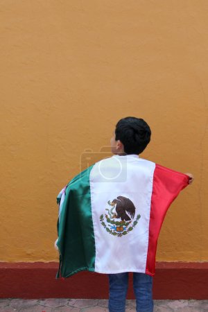 Téléchargez les photos : Latin Mexicain garçon de 8 ans montre le drapeau du Mexique fier de sa culture et de la tradition célèbre les fêtes nationales du 15 Septembre et Cinco de Mayo - en image libre de droit