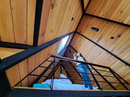 Téléchargez les photos : Femme adulte latine a un café du matin dans sa cabine dans les bois bénéficie de son temps libre pendant les vacances de week-end - en image libre de droit