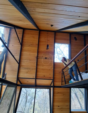 Téléchargez les photos : Femme adulte latine a un café du matin dans sa cabine dans les bois bénéficie de son temps libre pendant les vacances de week-end - en image libre de droit