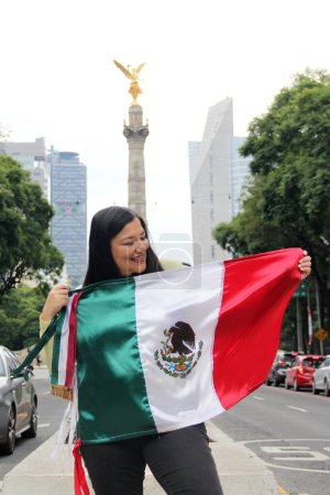 Photo for Latin adult woman shows the flag of mexico proud of the culture and tradition of her country, celebrates mexican patriotism - Royalty Free Image