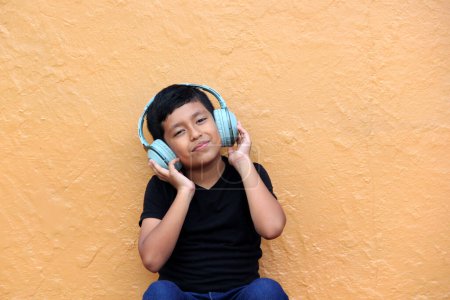 Brown Latino 9 year old boy with anti noise headphones for children with asperger syndrome, autism spectrum disorder, ADHD and children with sensitivity to loud noises