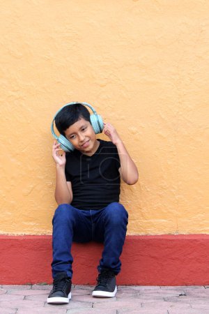 Téléchargez les photos : Brown Latino garçon de 9 ans avec casque anti-bruit pour les enfants atteints du syndrome d'asperger, du trouble du spectre autistique, du TDAH et les enfants sensibles aux bruits forts - en image libre de droit