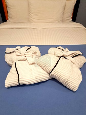 Foto de Albornoces blancos en la cama en la habitación listos para tomar un masaje, bañera, jacuzzi, descanso, relajación y comodidad - Imagen libre de derechos