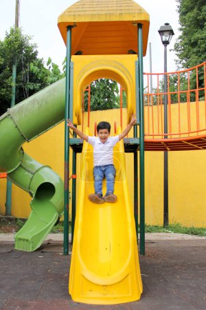Photo for 9-year-old dark-skinned Latino boy plays in a playground as a physical activity living in poverty as therapy for ADHD - Royalty Free Image