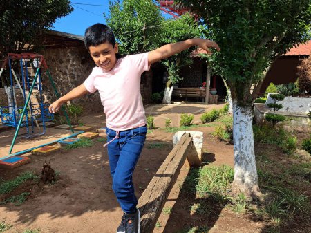 Niño latino de piel oscura de 9 años practica ejercicios de equilibrio para la rehabilitación del trastorno del espectro autista TEA