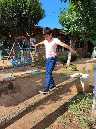 Téléchargez les photos : Enfant latino-américain de 9 ans pratiquant des exercices d'équilibre pour la réadaptation des troubles du spectre autistique TSA - en image libre de droit