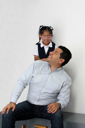 Geschiedener alleinerziehender Vater mit seiner 4-jährigen brünetten Latina-Tochter in Schuluniform, die nach der Schule Zeit miteinander verbringt