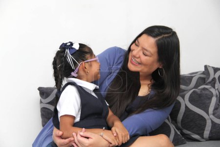 Téléchargez les photos : Divorcé célibataire maman latine et brune fille de 4 ans en uniforme et lunettes parler et jouer après l'école - en image libre de droit