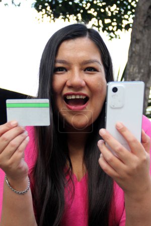 40-jährige Latina nutzt Handy und Kreditkarte, um zu bezahlen, online zu kaufen, Angebote und Rabatte im Internet zu nutzen