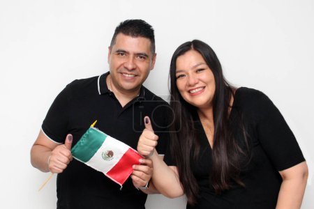 Paar mexikanischer Latinos zeigt nach Ausübung ihrer Stimme mit unauslöschlicher Wahltinte befleckte Daumen