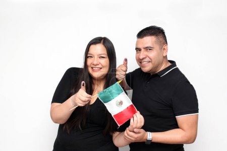 Couple of Mexican Latino man and woman show their thumbs stained with indelible electoral ink after exercising their vote