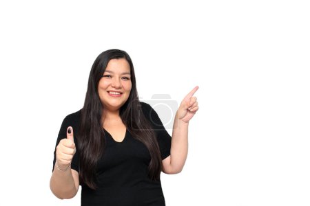 Téléchargez les photos : Une Latina de 40 ans montre son pouce encré à l'encre indélébile après avoir voté librement et secrètement dans la boîte électorale - en image libre de droit