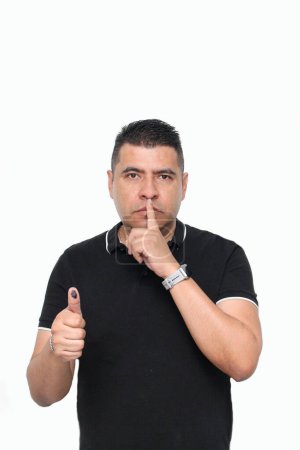 Der erwachsene Latino zeigt seinen mit unauslöschlicher Wahltinte eingefärbten Daumen, nachdem er von seinem Recht auf freie und geheime Wahl Gebrauch gemacht hat