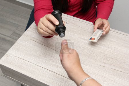 Tinta electoral indeleble que marca el pulgar de la mano de un votante en las elecciones que muestra su tarjeta de votación