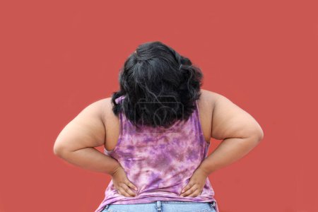 Junge brünette Latino-Frau von 20 Jahren leidet unter Rücken-, Wirbelsäulen- und Nackenschmerzen aufgrund von Verspannungen und schlechter Körperhaltung