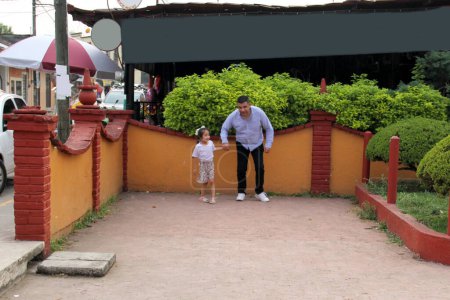 Divorcé père célibataire joue avec sa fille latina de 5 ans dans le parc, ils courent et s'amusent à célébrer la fête des pères